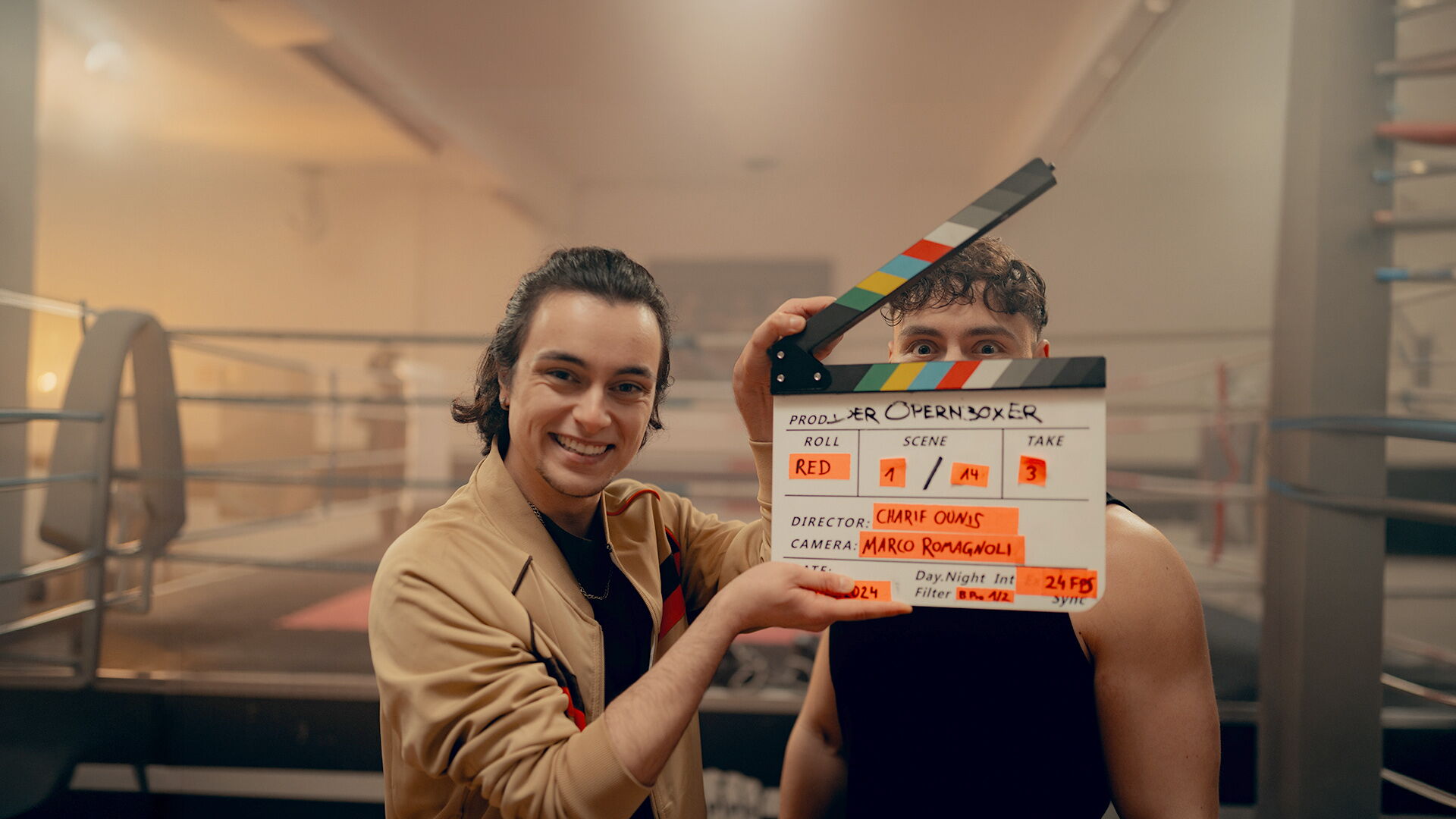 Schauspieler mit Filmklappe zum Abschlussfilm Opernboxer am Boxring